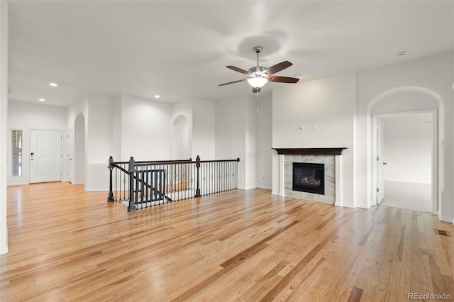 2423 Delicato Ct, Colorado Springs, CO 80921 - unfurnished living room featuring arched walkways, recessed lighting, wood finished floors, a ceiling fan, and a fireplace