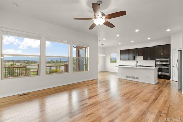 2423 Delicato Ct, Colorado Springs, CO 80921 - unfurnished living room with a sink, a ceiling fan, recessed lighting, light wood-style floors, and baseboards