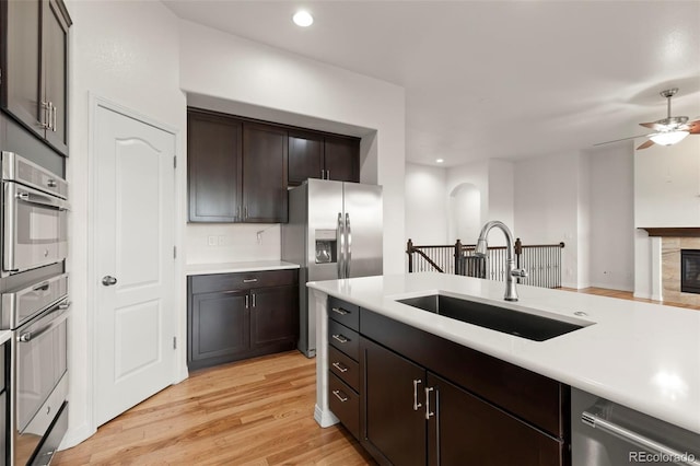2423 Delicato Ct, Colorado Springs, CO 80921 - kitchen featuring a sink, stainless steel appliances, light countertops, light wood finished floors, and a ceiling fan