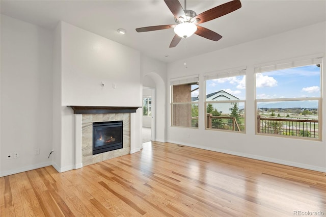2423 Delicato Ct, Colorado Springs, CO 80921 - unfurnished living room with light wood-type flooring, plenty of natural light, a tile fireplace, and baseboards