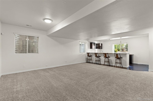 2423 Delicato Ct, Colorado Springs, CO 80921 - unfurnished living room featuring carpet, wet bar, and baseboards