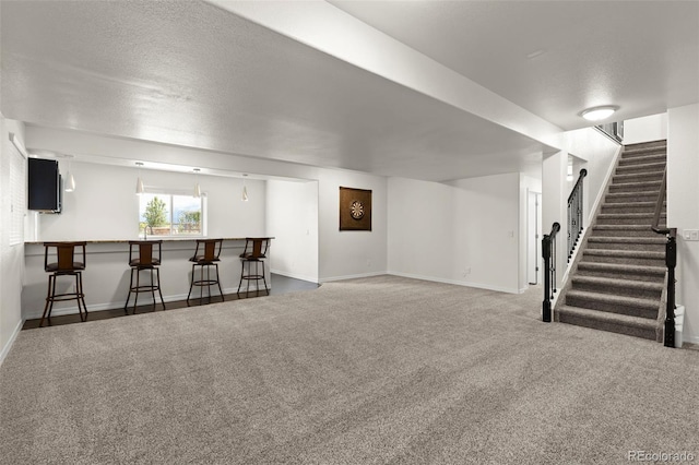 2423 Delicato Ct, Colorado Springs, CO 80921 - below grade area featuring carpet, bar, stairway, baseboards, and a textured ceiling