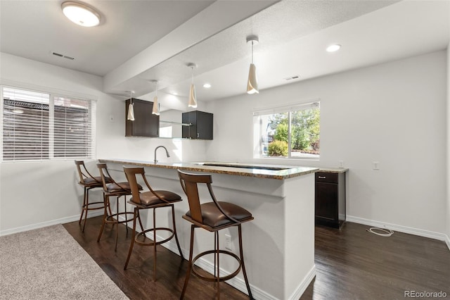 2423 Delicato Ct, Colorado Springs, CO 80921 - kitchen with a kitchen breakfast bar, dark wood-style flooring, baseboards, a peninsula, and recessed lighting