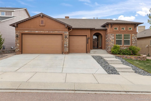 2423 Delicato Ct, Colorado Springs, CO 80921 - view of front of home featuring stone siding, stucco siding, a garage, and driveway
