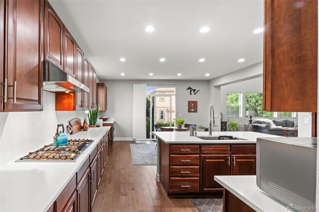 5984 S Paris Pl, Greenwood Village, CO 80111 - kitchen with stainless steel gas cooktop, light countertops, dark wood-style flooring, recessed lighting, and under cabinet range hood
