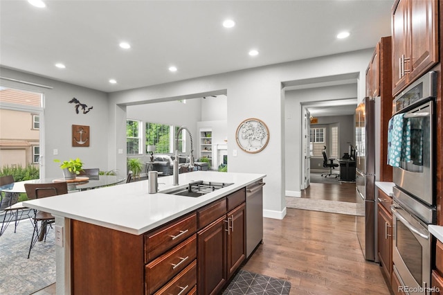 5984 S Paris Pl, Greenwood Village, CO 80111 - kitchen featuring recessed lighting, light countertops, appliances with stainless steel finishes, dark wood-style flooring, and an island with sink