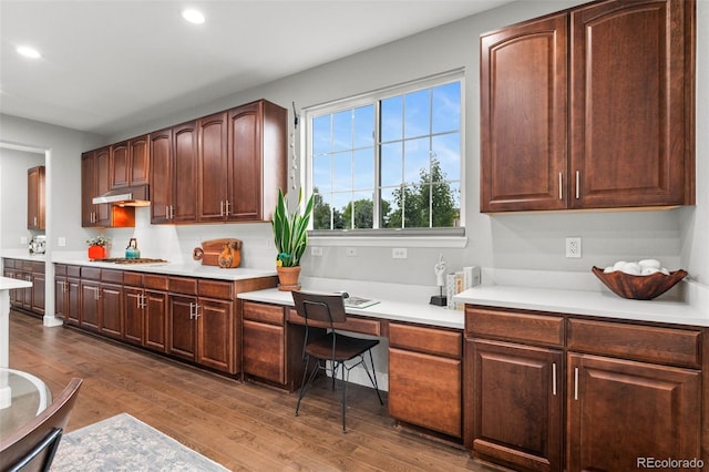 5984 S Paris Pl, Greenwood Village, CO 80111 - kitchen featuring under cabinet range hood, recessed lighting, built in desk, dark wood finished floors, and light countertops