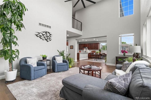 5984 S Paris Pl, Greenwood Village, CO 80111 - living room featuring ceiling fan, a towering ceiling, and dark wood-type flooring
