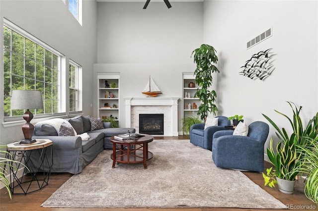 5984 S Paris Pl, Greenwood Village, CO 80111 - living area with a high ceiling, wood finished floors, a glass covered fireplace, ceiling fan, and built in features