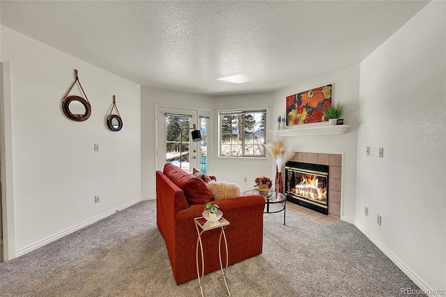 carpeted living room with a textured ceiling and a tiled fireplace