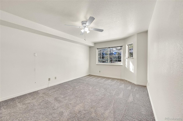 carpeted empty room featuring ceiling fan and a textured ceiling