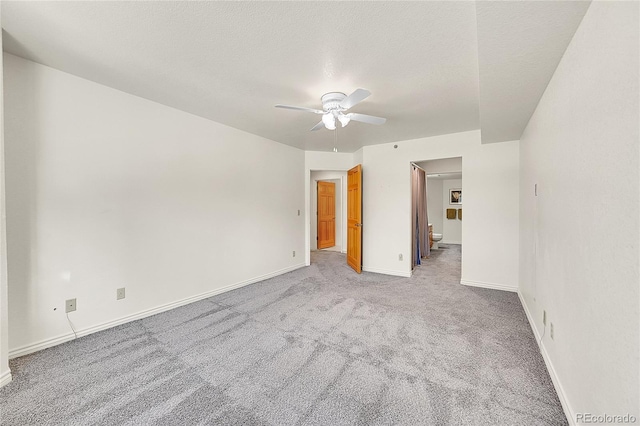 carpeted empty room featuring ceiling fan and a textured ceiling