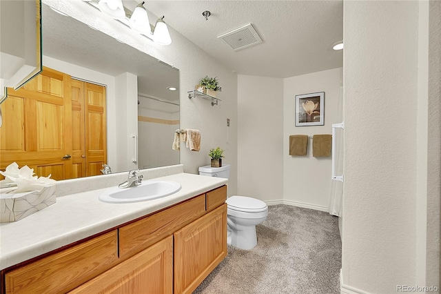 bathroom with toilet, a textured ceiling, and vanity