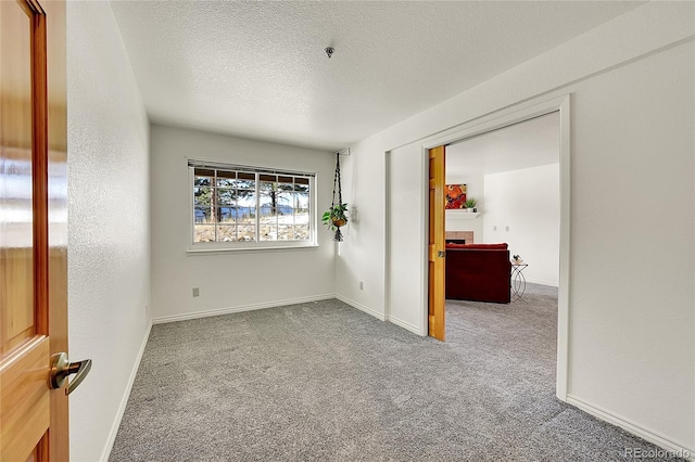 carpeted spare room featuring a textured ceiling