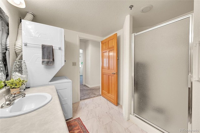 bathroom with a textured ceiling, walk in shower, and vanity