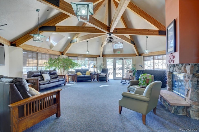 living room with ceiling fan, carpet, beamed ceiling, a stone fireplace, and high vaulted ceiling