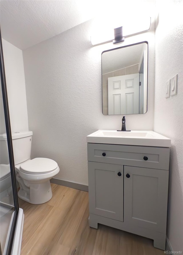 4476 S Grant St, Englewood, CO 80113 - bathroom with wood finished floors, vanity, toilet, and baseboards