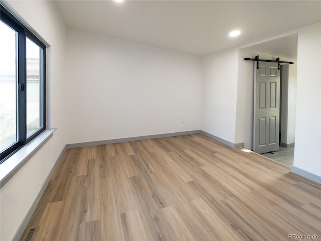 4476 S Grant St, Englewood, CO 80113 - spare room with light wood finished floors, baseboards, recessed lighting, and a barn door