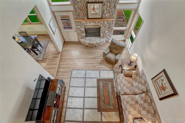 18470 Canterbury Dr, Monument, CO 80132 - living room featuring a high ceiling, a stone fireplace, and wood finished floors