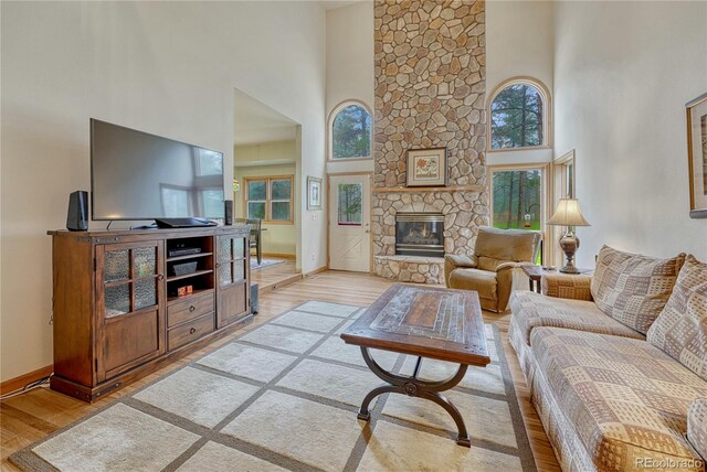18470 Canterbury Dr, Monument, CO 80132 - living room featuring a high ceiling, light wood-style floors, and a fireplace
