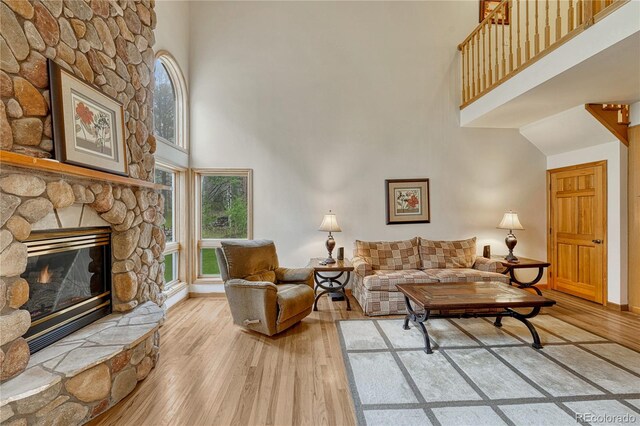 18470 Canterbury Dr, Monument, CO 80132 - living area with a high ceiling, light wood-style flooring, and a fireplace