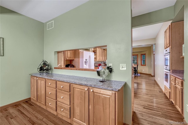 18470 Canterbury Dr, Monument, CO 80132 - kitchen featuring white fridge with ice dispenser, light wood-style floors, and double oven