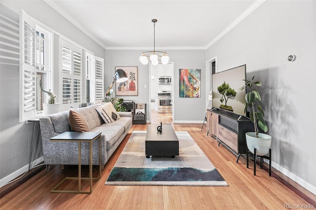 living room with hardwood / wood-style flooring, ornamental molding, and an inviting chandelier