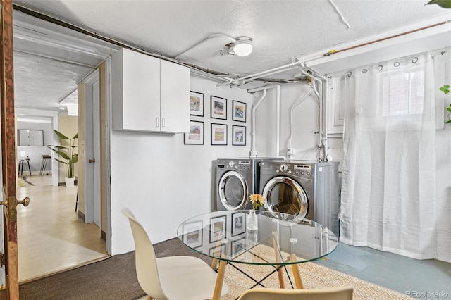 laundry room with a textured ceiling and washer and dryer