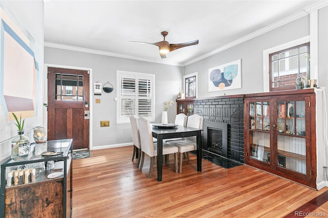 525 N Pearl St, Denver, CO 80203 - dining space featuring light wood finished floors, ornamental molding, a fireplace, and a healthy amount of sunlight