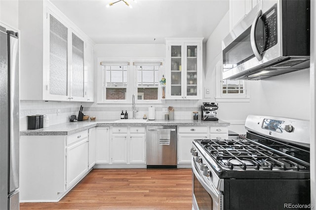 525 N Pearl St, Denver, CO 80203 - kitchen with a sink, backsplash, light countertops, white cabinets, and appliances with stainless steel finishes