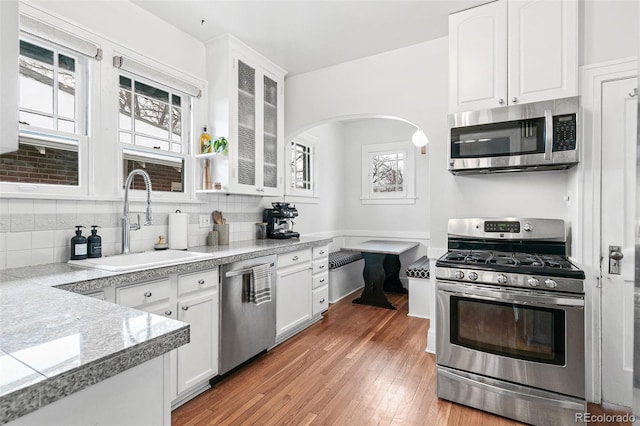 525 N Pearl St, Denver, CO 80203 - kitchen featuring white cabinets, glass insert cabinets, stainless steel appliances, and a sink