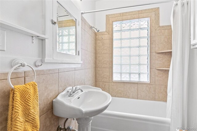 525 N Pearl St, Denver, CO 80203 - bathroom featuring tile walls, shower / bath combo with shower curtain, and a sink