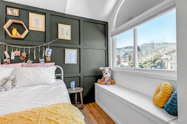 bedroom with light wood-style flooring and a decorative wall