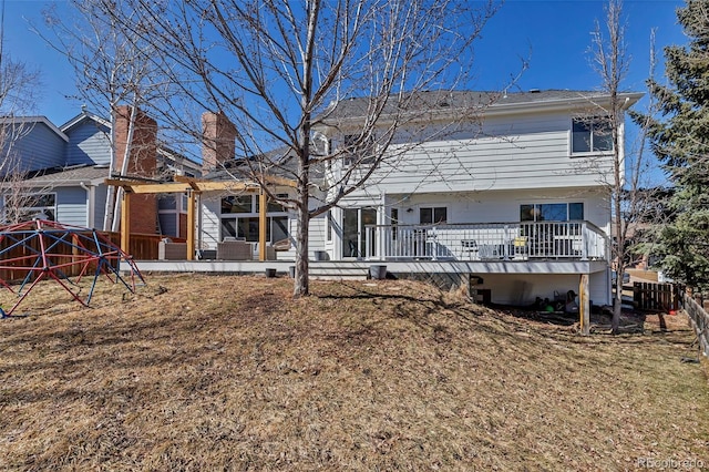 rear view of property with a deck and fence