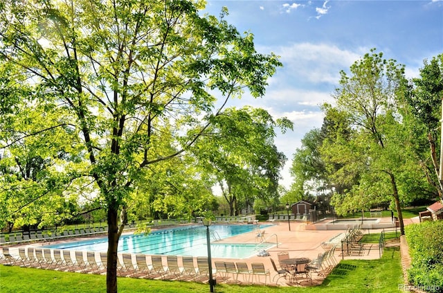 pool with a patio and fence