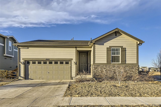 single story home featuring concrete driveway, stone siding, an attached garage, and fence