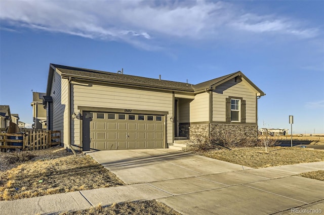 ranch-style home with a garage, stone siding, fence, and concrete driveway