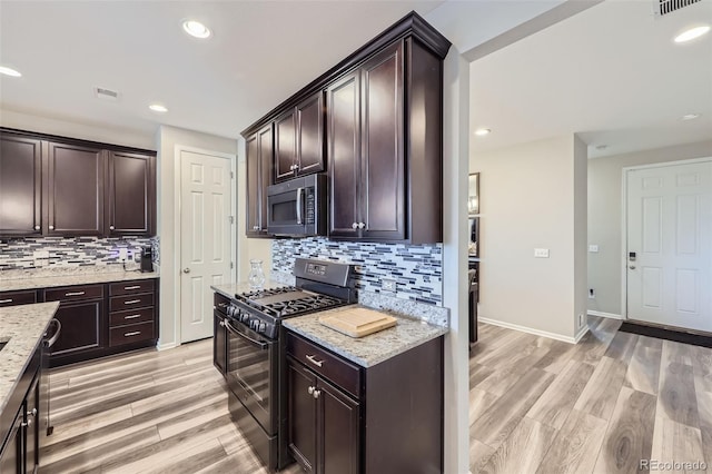 kitchen with dark brown cabinetry, visible vents, light wood finished floors, stainless steel microwave, and gas stove