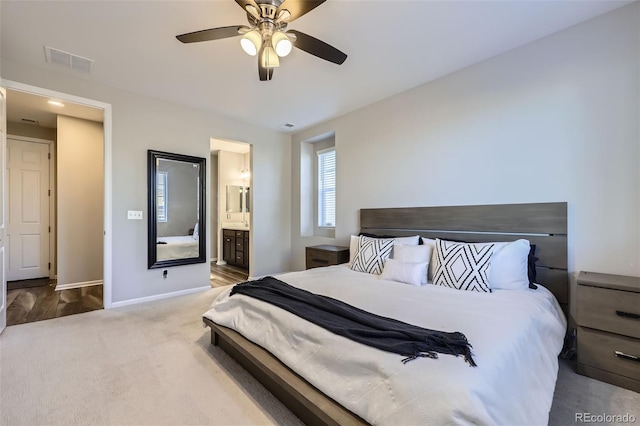 bedroom with ensuite bathroom, carpet floors, a ceiling fan, visible vents, and baseboards