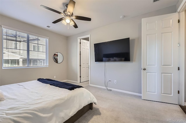 bedroom featuring baseboards, visible vents, a ceiling fan, and light colored carpet