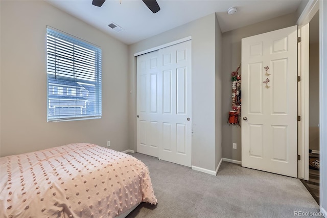 carpeted bedroom with a ceiling fan, baseboards, visible vents, and a closet