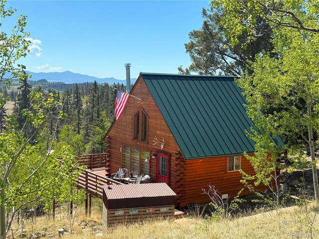 179 Mountain Vis, Como, CO 80432 - view of home's exterior featuring a standing seam roof, a deck with mountain view, metal roof, and log exterior