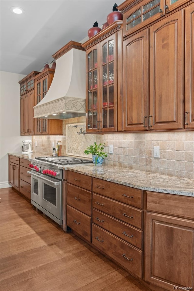 1160 Monaco Pkwy, Denver, CO 80220 - kitchen with range with two ovens, premium range hood, light wood-style floors, light stone counters, and recessed lighting