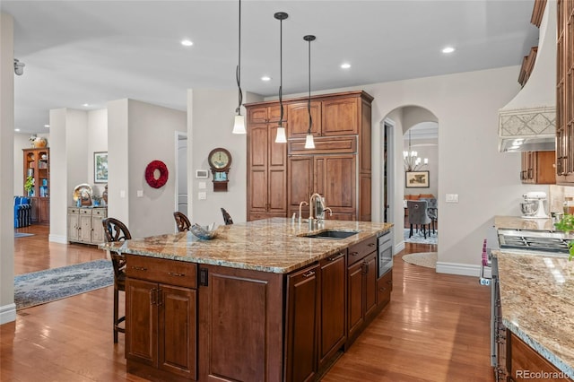 1160 Monaco Pkwy, Denver, CO 80220 - kitchen featuring stainless steel appliances, premium range hood, wood finished floors, a breakfast bar area, and recessed lighting