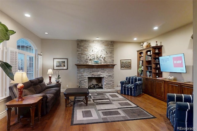 1160 Monaco Pkwy, Denver, CO 80220 - living room featuring wood finished floors, recessed lighting, and a stone fireplace
