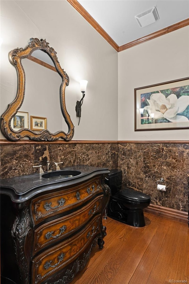 1160 Monaco Pkwy, Denver, CO 80220 - bathroom featuring vanity, wood finished floors, crown molding, wainscoting, and tile walls