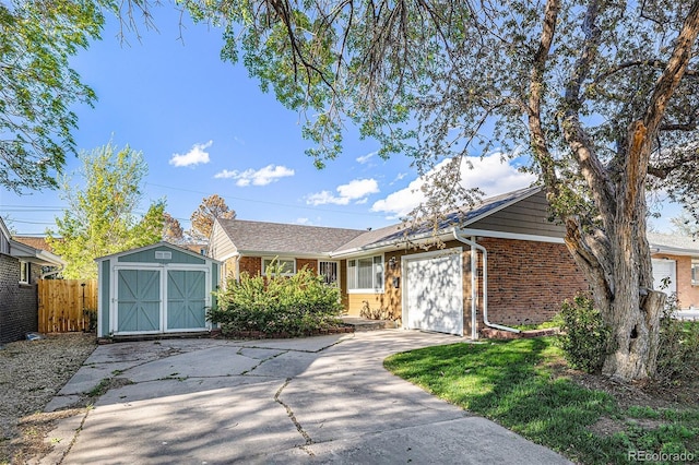 single story home featuring brick siding, driveway, an attached garage, and a storage shed