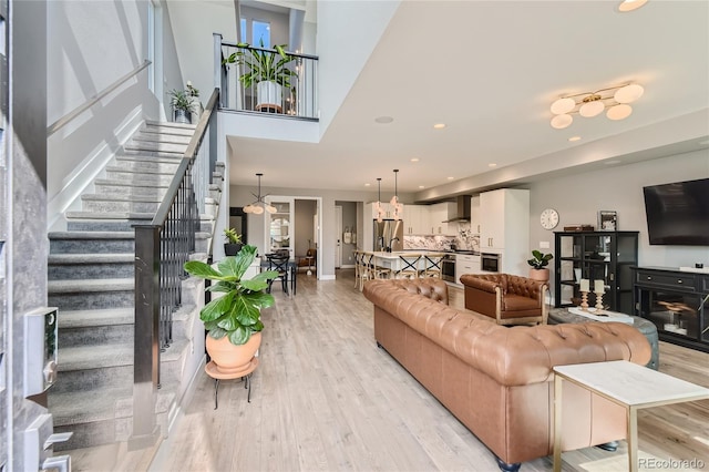 living area featuring stairway, recessed lighting, and light wood-style floors