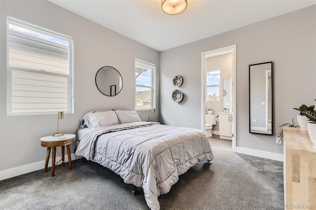 carpeted bedroom with connected bathroom and baseboards