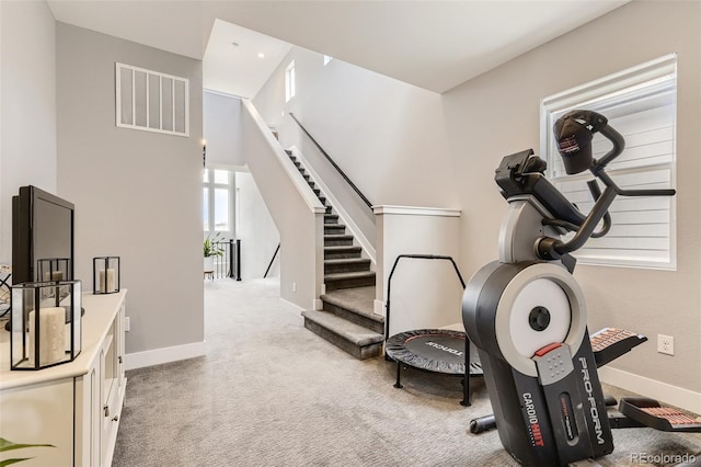 workout room featuring light colored carpet, visible vents, and baseboards